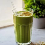 Matcha tea protein shake with powdered matcha and hemp hearts in a tall glass