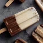 Vanilla and chocolate protein popsicles layered and swirled on concrete background